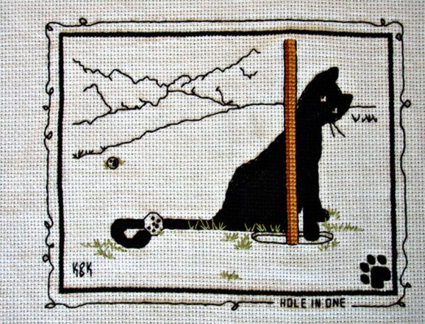 Cross Stitch Embroidery picture of a cat and text saying "Hole in One" for framing